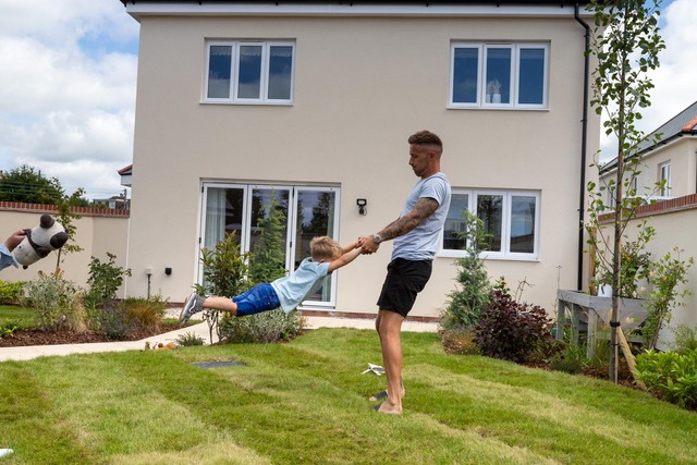 Dad swinging kid in garden