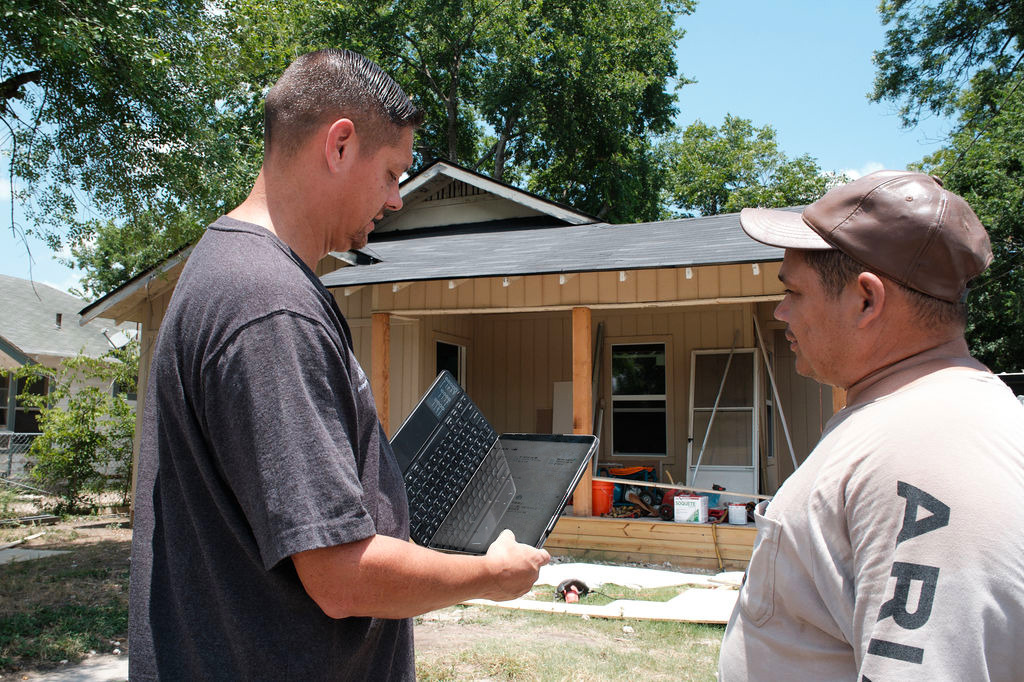 A builder manages his team schedule from the job site using Buildxact running on his mobile device