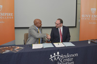 Anderson Center Executive Director and CEO Patrick Paul '94, a SUNY Empire alumnus, and Officer in Charge Mitchell S. Nesler, shake hands after formalizing the partnership between the two organizations.