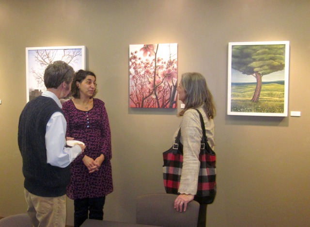 Image of people talking in front of art hanging on the wall