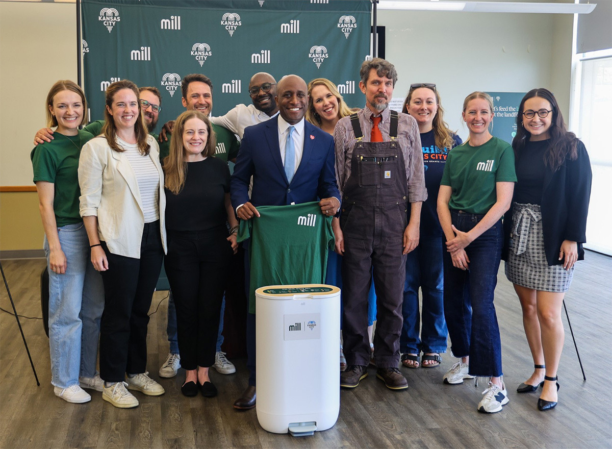 Group with Kansas City Mayor Quinton Lucas and Mill food recycler at center, Mill logos in background.