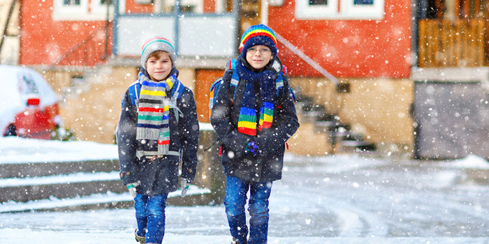Two boys walking at school in snow
