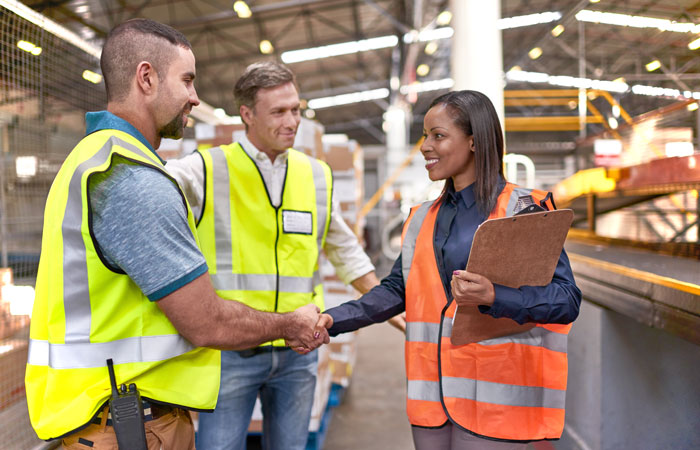 People in a warehouse shaking hands