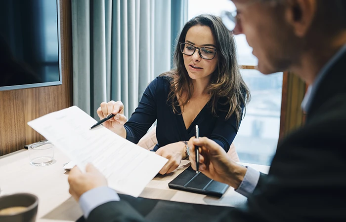 Two people working in an office looking at a document