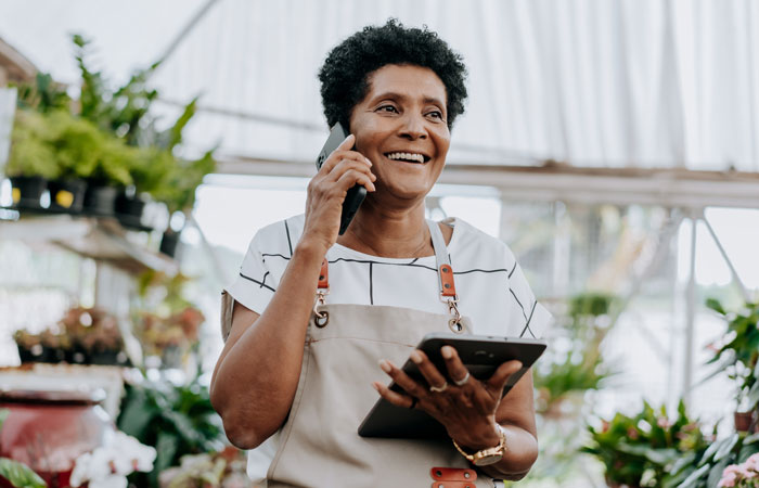 A woman on the phone in a gardening shop