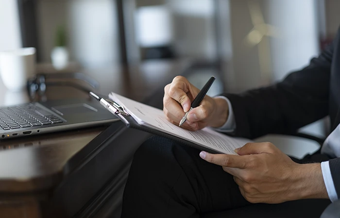 A close up of someone writing on a legal pad