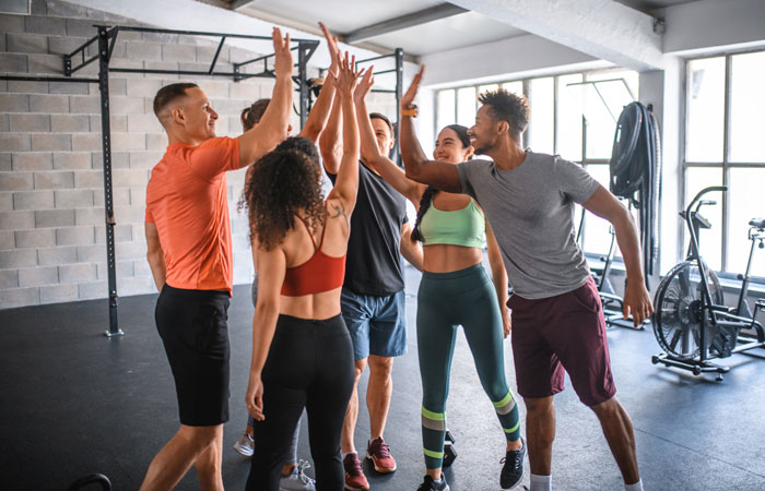 Group of people high-fiving in a gym