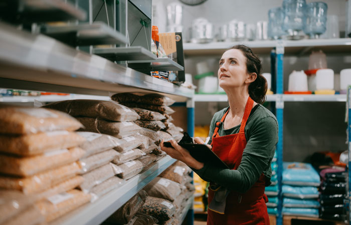 A woman taking inventory in a feed store