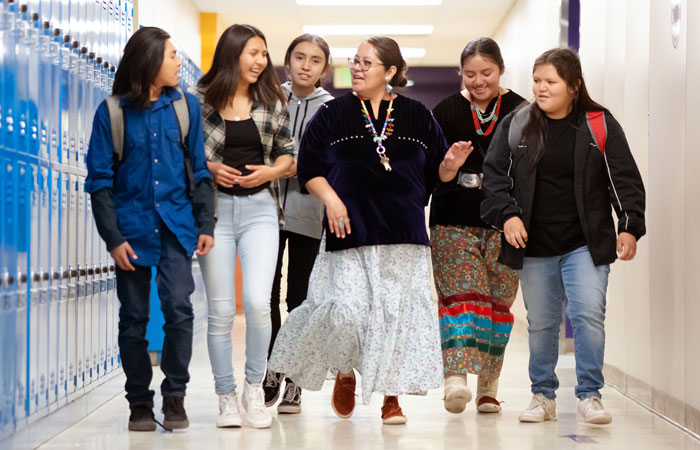 A teacher walking down the hall with a group of students