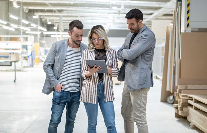 People looking at a tablet while working in a warehouse