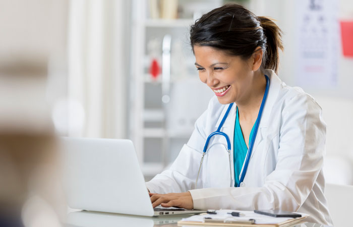 A doctor working on a laptop