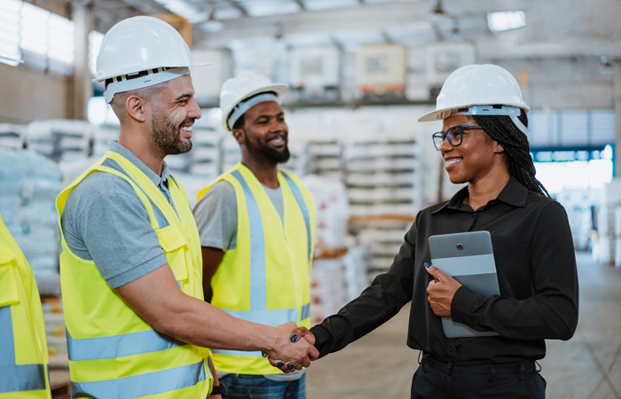 Two people shaking hands in a warehouse