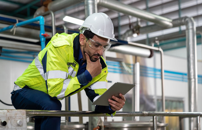 A man working on a tablet in a warehouse. 