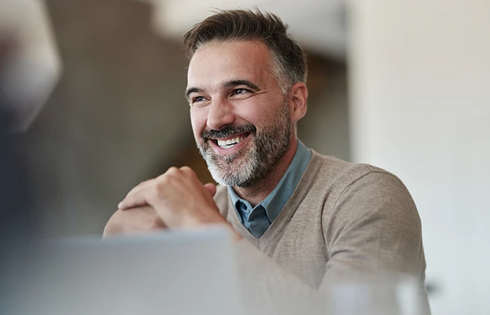 A man in an office smiling