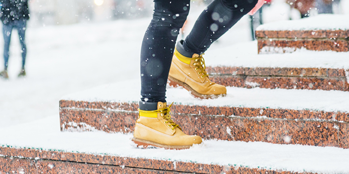 person walking up steps covered in snow