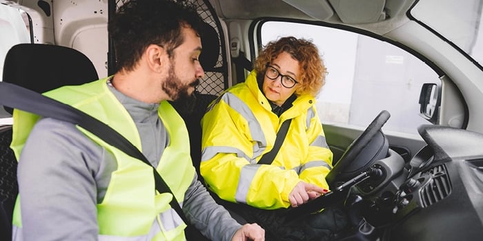 Two workers talking in a truck together