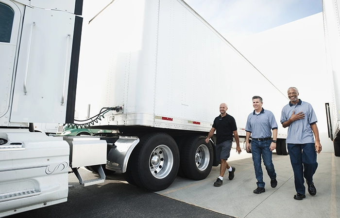 Workers walking by a freight truck