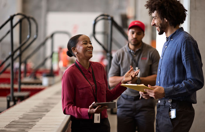 Three people having a meeting in a warehouse