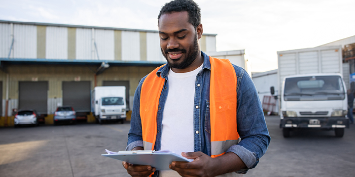 Man wearing safety vest and holding clipboard