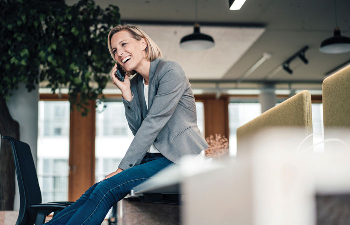 A woman talking on the phone sitting in an office