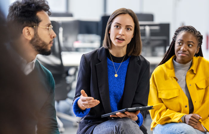 A woman talking in a meeting while everyone looks at her