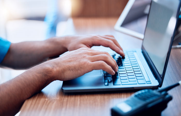 a close-up of a first responder working on a laptop