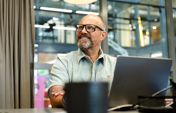 A man sitting in their office working on a laptop