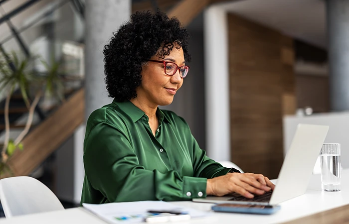 A woman working on a laptop in an office