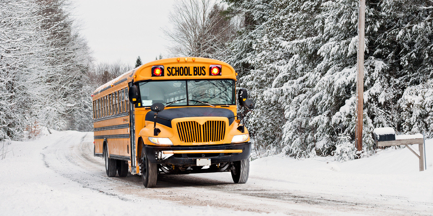 school bus driving down a snowy road