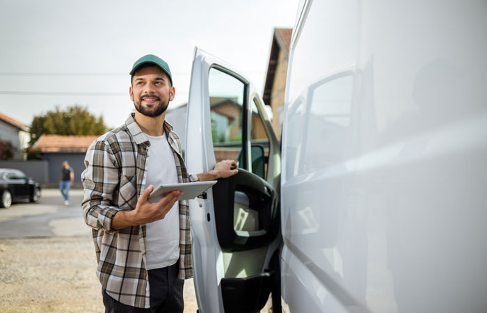 A man standing outside of his work vehicle