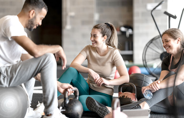 People sitting around weights at the gym