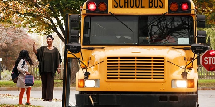 girl getting on school bus
