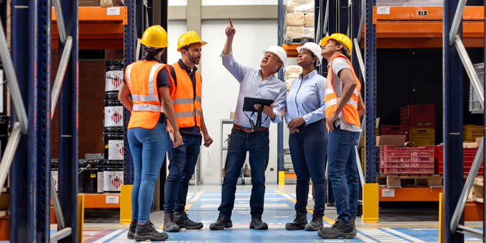 safety manager and workers wearing a hard hat in a warehouse