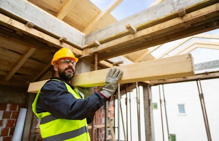 A contractor carrying materials in a job site