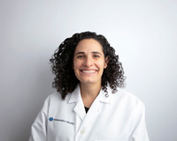 Kira Andersen smiling and wearing white coat