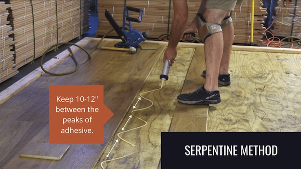 Person spreading flooring adhesive in serpentine method