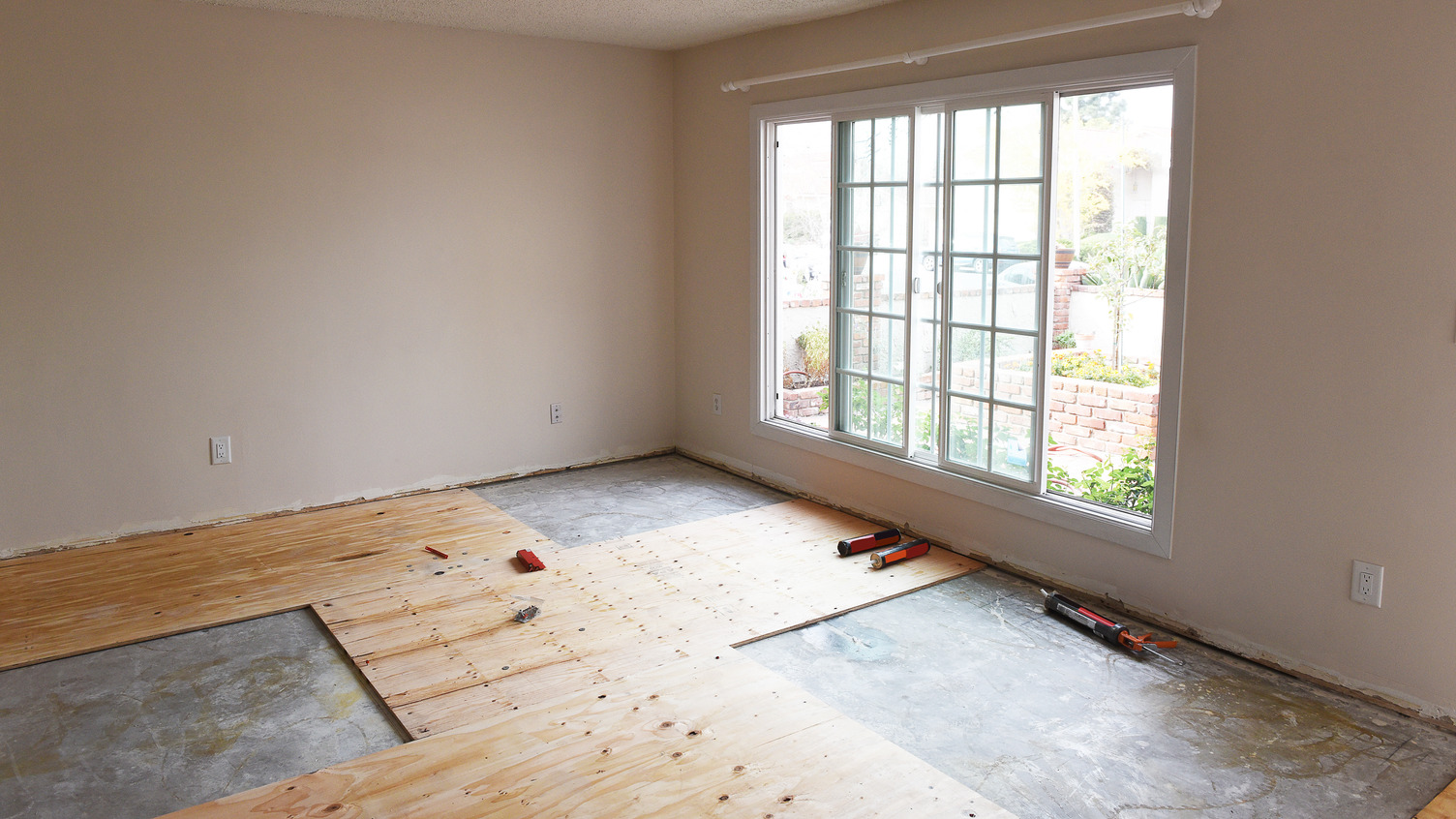 Subfloor being installed in room with large window